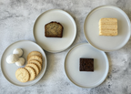Five plates with different types of food on a textured gray surface